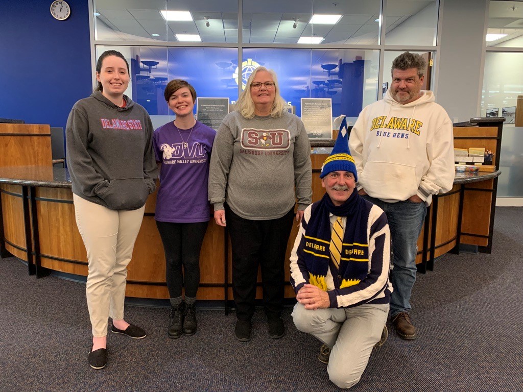 Public Archives staff wearing favorite college shirts.