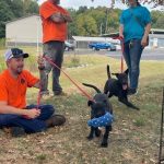 A DelDOT employee holds the leash of a dog while another employee chats with a representative from Faithful Friends Animal Society at the "Cuddle a Dog" event.