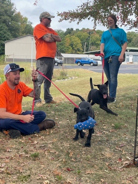 A DelDOT employee holds the leash of a dog while another employee chats with a representative from Faithful Friends Animal Society at the "Cuddle a Dog" event.