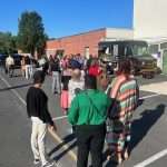 Alt text: "Employees stand in line at a food truck in the parking lot outside the Delaware Office of the Marijuana Commissioner in Dover, participating in a fundraiser for the State Employees' Charitable Campaign.