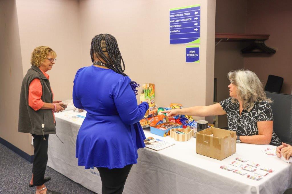 Two people purchasing bake sale items